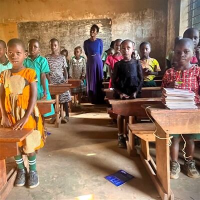 Teacher and students posing for a picture in the classroom.